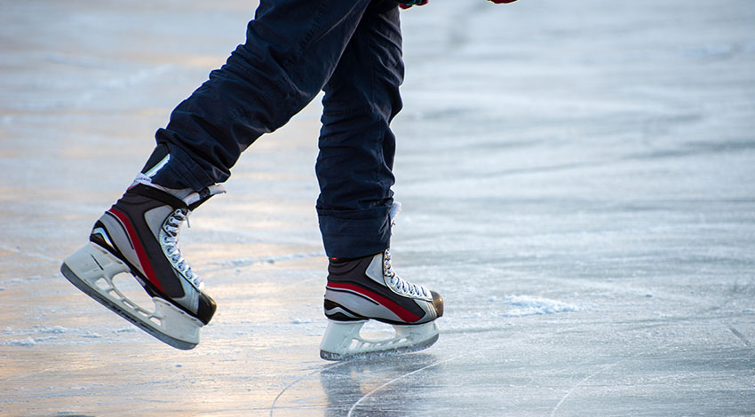 Person mit Schlittschuhen auf dem Eis. © Adobe Stock, Andrey Bodrov
